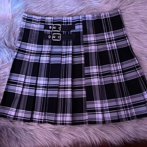 Medium size pleated skirt with buckle detail in the front